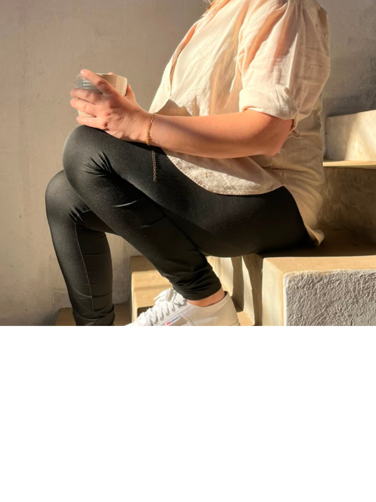 Person sitting on steps holding coffee cup